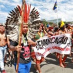 Povos originários protestando em via pública pelos direitos indígenas.