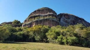 Parque Natural Municipal da Pedra do Segredo mostra grande rocha arredondada e vegetação