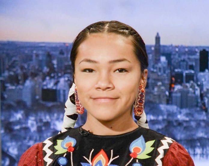Autumn Peltier usando roupas indígenas posando para foto sobre questões ambientais