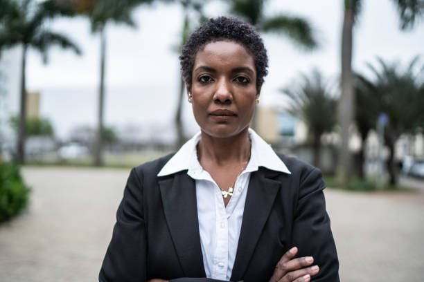 Uma mulher negra de meia idade protesta sozinha contra o racismo estrutural.