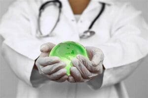 um médico segura com as duas mãos um globo Saúde ambiental terrestre esverdeado que representa a saúde ambiental do planeta