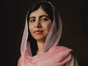 Malala Yousafzai com véu, posando para foto com vestido rosa