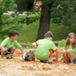 Crianças plantam em um parque, recebendo a educação climática