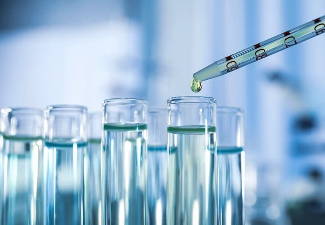 Tubos de ensaio alinhados e outro com conta gotas derramando um líquido produzido pela nanobiotecnologia