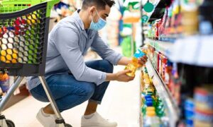 Um rapaz em um supermercado escolhe produtos baseado no consumo responsável