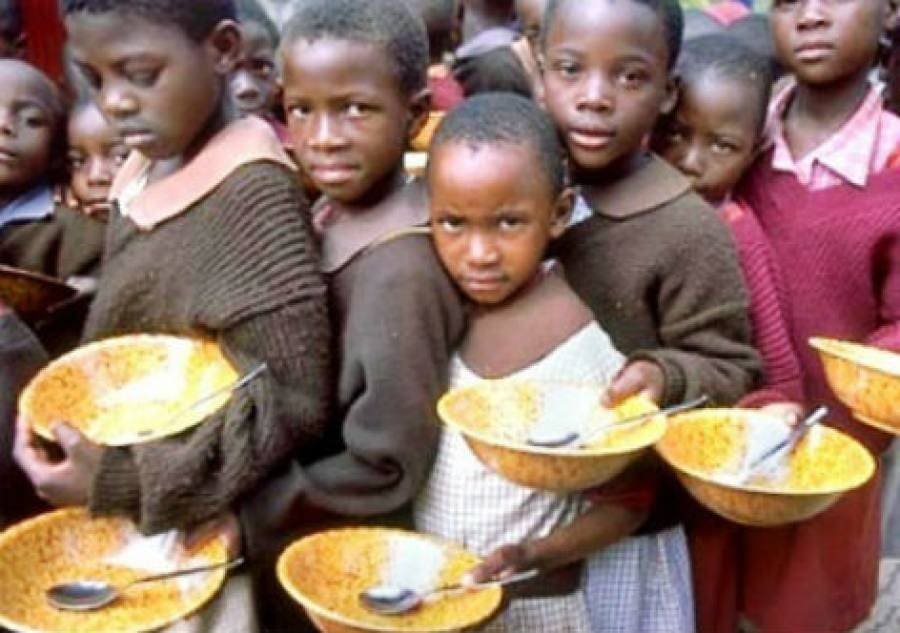 Dezenas de crianças com pratos na mão aguardam uma solução para a crise alimentar
