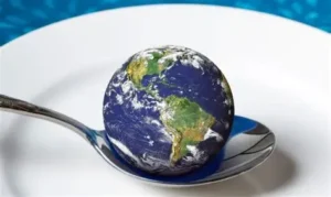 Em um prato uma colher sustenta o mundo, representando a injustiça alimentar