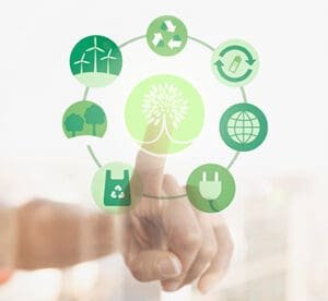 Representação de padrões de consumo sustentável e consciente com uma mão tocando um ícone digital de árvore, rodeado por símbolos verdes de energia renovável, reciclagem, preservação ambiental e consumo consciente.