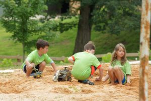Crianças plantam em um parque, recebendo a educação climática